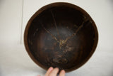 Dark wood interior of the vintage African wooden bowl, showing extensive aged cracks.
