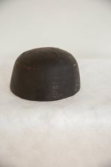 Vintage dark brown African wooden bowl with carved zigzag patterns and metal repairs.
