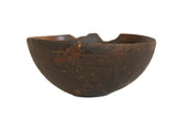 Vintage African wooden bowl, dark brown with aged character and visible rustic repairs.
