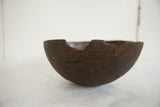 Textured dark brown surface, aged cracks, and irregular edge of the vintage wooden bowl.