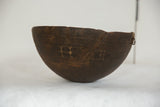 Aged dark wood texture and rounded bottom of the vintage African bowl.