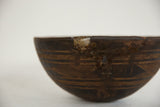 Vintage African Wooden Bowl: metal staple repair and carved lines on aged wood.