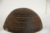 Engraved geometric patterns and metal repair patch on vintage African wooden bowl side.