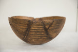 Close-up of the vintage African wooden bowl's aged surface, with etched lines and rustic repairs.