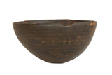 Vintage handmade African wooden bowl with carved geometric patterns, dark brown aged wood.