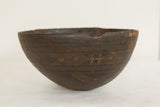Vintage African wooden bowl, dark brown with carved geometric patterns and textured surface.