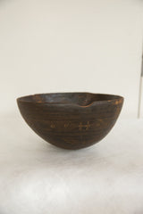 Vintage African wooden bowl detail, showing carved geometric patterns and aged texture.