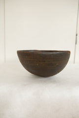 Dark brown patina and subtle carved geometric patterns on a vintage African wooden bowl.