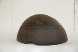 Aged dark African wooden bowl side view, revealing carved geometric lines and patterns.