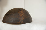 Vintage African wooden bowl with dark wood, carved geometric patterns, and storied repair.