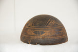 Vintage African wooden bowl detail, dark aged wood with carved geometric patterns.