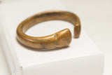 Warm bronze patina on the smooth, handcrafted form of an antique African bracelet.