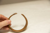 Hand holds antique African copper bracelet, showing its rich, time-softened patina.
