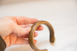 The smooth, substantial curve of the antique African bronze cuff held for scale.