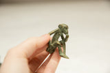 A small African bronze monkey sculpture held in hand to demonstrate its petite size.