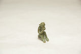 Vintage African bronze monkey sculpture in a pensive pose, showing its textured green patina.