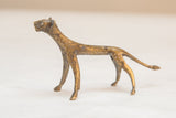 Side profile of vintage African bronze cheetah with aged, textured surface.