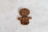 Vintage African wooden pendant showing the details of its hand-carved form and aged surface.
