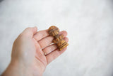 Vintage African wooden person pendant held in hand to show its scale and carved details.