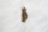 Aged patina and textured surface of a mid-century African bronze abstract pendant.