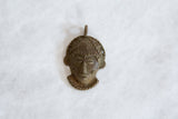 Vintage African bronze mask pendant with a weathered patina and hand-cast details.