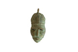 Vintage African oxidized bronze mask pendant with a textured surface and aged green patina.