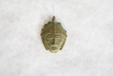 Handmade African mask pendant with a textured, oxidized bronze and green finish.
