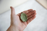 The concave reverse of the African bronze pendant showing a heavy, textured green patina.