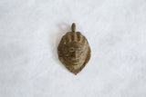 Vintage African bronze mask pendant with rustic handmade details and an aged patina.