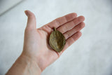 Concave back of the vintage bronze pendant showing its rustic, handmade texture.