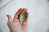 Hollowed back of the vintage African mask pendant showing its textured green patina.