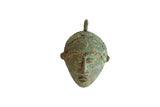 Vintage African mask pendant in oxidized bronze with a rich green patina and handmade texture.