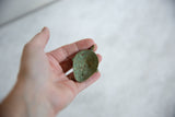 The concave reverse side of the African bronze pendant, showing its textured green patina.