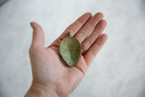 Back of vintage African bronze pendant showing its concave interior and oxidized green patina.
