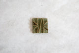 The unique raised pattern and textured patina of a handmade African bronze coin.