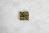 Aged green patina on vintage African square oxidized bronze coin detail.