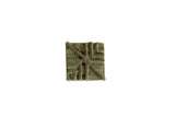 Square vintage African bronze coin with a geometric design and heavy green oxidized patina.