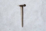 Reverse side of the handmade bronze chameleon pin and its long stick.