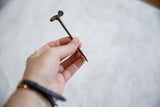 Vintage African bronze chameleon pin held in hand to showcase its length and handmade charm.