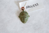 The detailed, etched features and oxidized patina of a vintage African mask pendant.
