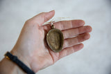 The concave reverse of the African bronze pendant showing an aged, handmade texture.