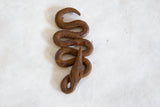 Hand-coiled vintage African iron snake sculpture, displaying rustic, rich brown patina.