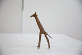 Profile view of the vintage bronze giraffe sculpture, highlighting its rustic, aged patina.