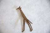 A vintage African bronze giraffe sculpture showing its slender, rustic form from above.