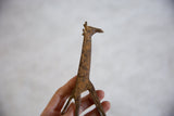 Vintage bronze alloy giraffe held in hand to show its scale and rustic patina.