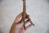 A view of the slender, hand-cast legs and textured body of the bronze giraffe.