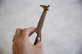 A vintage bronze alloy giraffe held in hand to show its scale and textured patina.