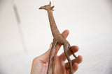 Hand holding the vintage African bronze giraffe, showing its rich, textured patina.