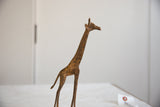 Vintage African bronze giraffe sculpture showing its textured patina and slender profile.