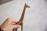 Vintage bronze alloy giraffe held to show its handcrafted texture and scale.